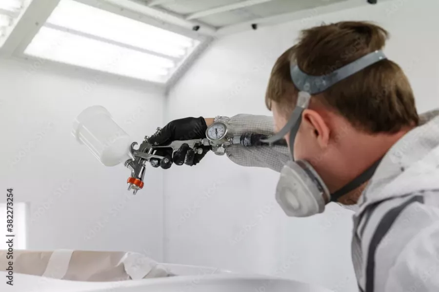 Visuel présentant un zoom sur un employé Creaform portant un masque dans une cabine peinture