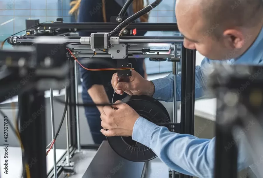 Visuel présentant un employé de Creaform qui démarre une machine pour réaliser une impression 3D