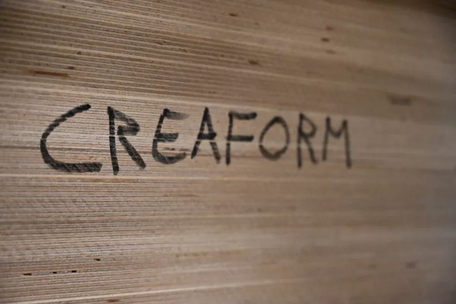 Visuel présentant une gravure de Creaform en bas-relief sur du bois