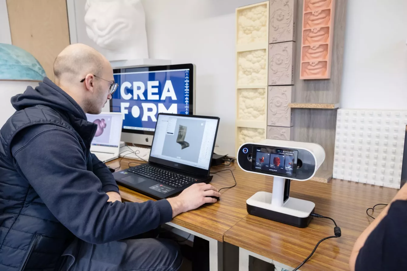 Visuel présentant un employé de Creaform assis devant des ordinateurs lui permettant de réaliser de la modélisation 3D