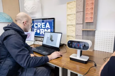 Visuel présentant un employé de Creaform assis devant des ordinateurs lui permettant de réaliser de la modélisation 3D