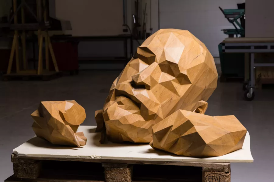 Visuel présentant une pièce monumentale d'un visage en bois réalisée par Creaform