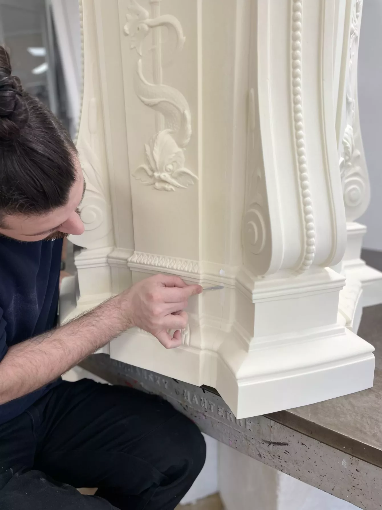 Visuel présentant un employé en train de réaliser une restauration du patrimoine sur une colonne