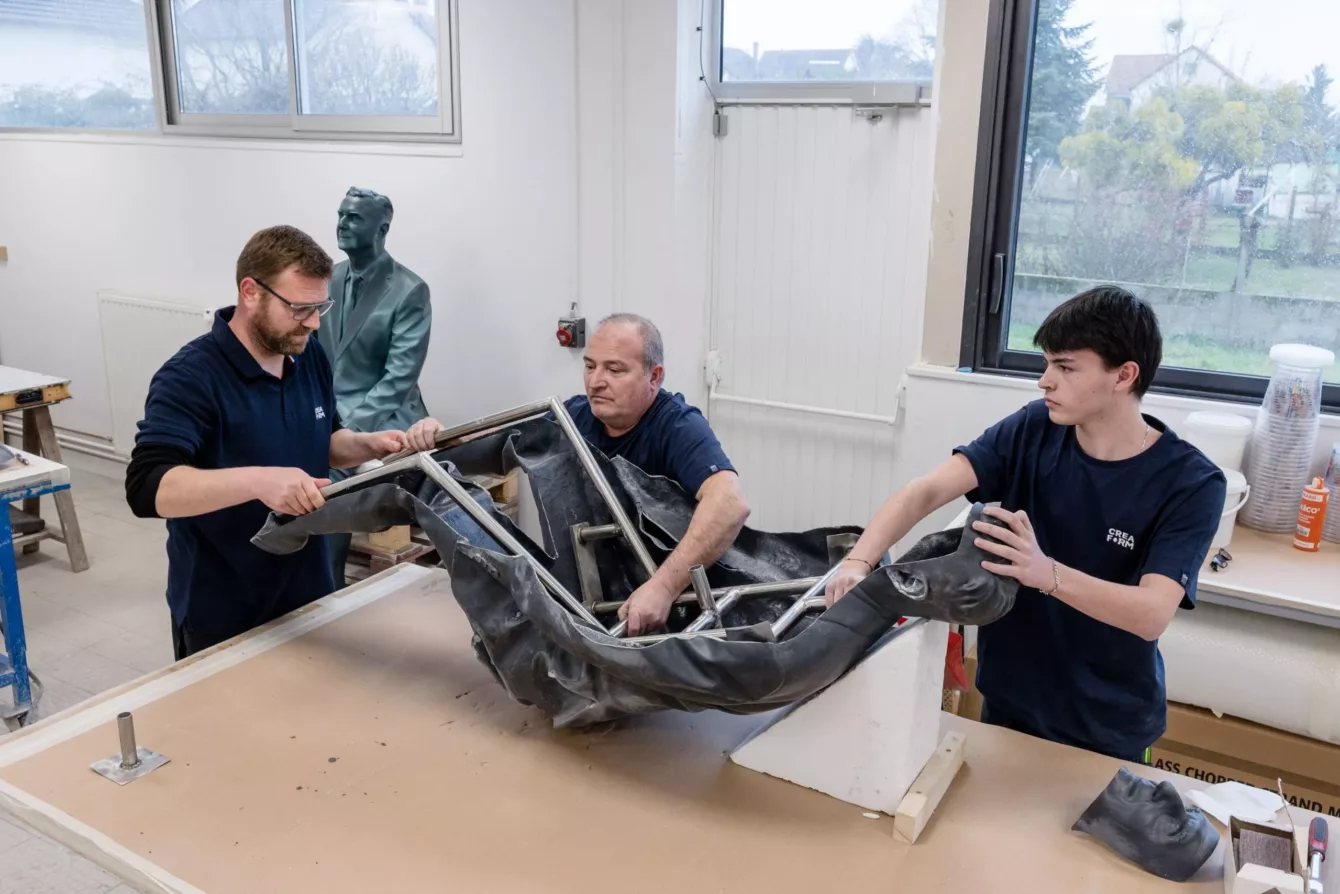 Visuel présentant des salariés de Creaform en train de travailler sur le morceau d'une pièce monumentale