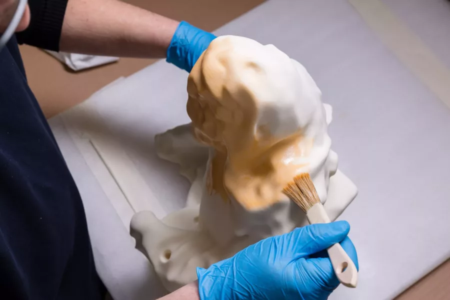 Visuel présentant un employé Creaform qui applique de la peinture jaune sur une sculpture