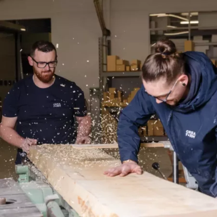 Visuel présentant des employés de l'entreprise Creaform en train de découper du bois avec une scie